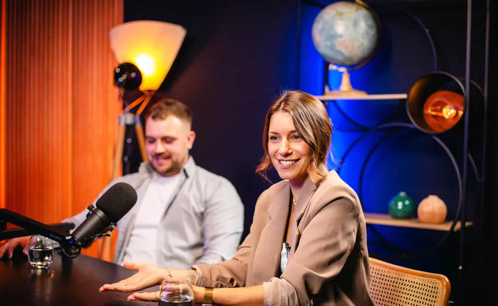 Interview-Situation mit Mikrofon, Globus-Regal und blauem Hintergrund