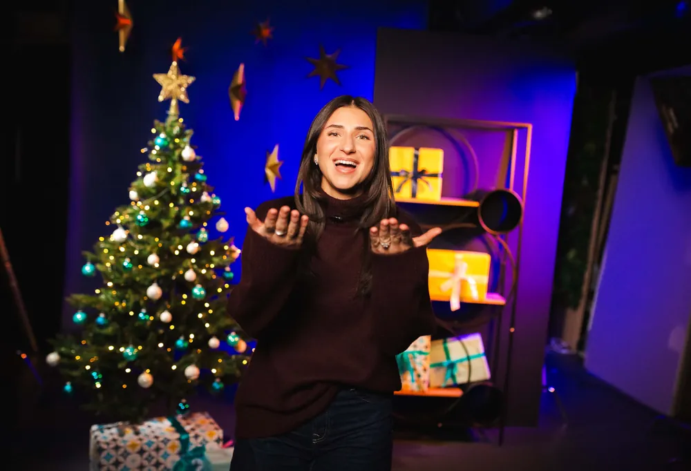 Weihnachts-Set mit Tannenbaum, Sternen und Geschenkregal, lachende Frau